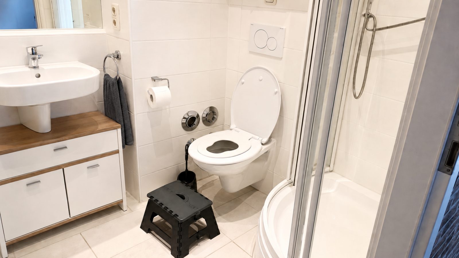 Helles Bad mit Dusche, Waschbecken, WC mit integriertem Kindersitz und Tritthocker