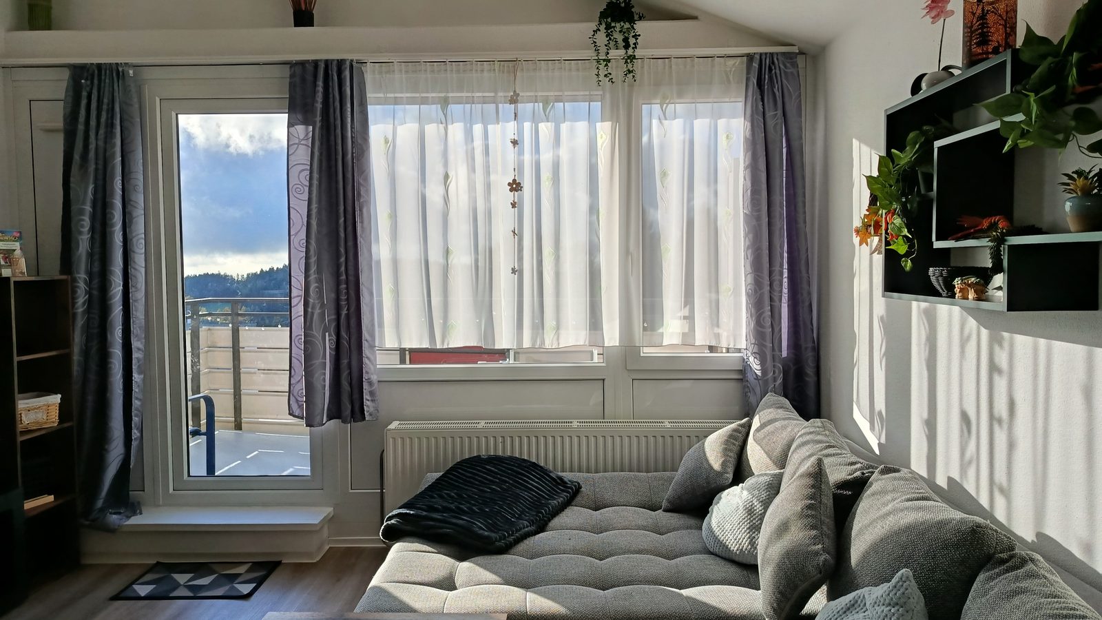 Heller Wohnbereich mit Sofa und Balkonblick