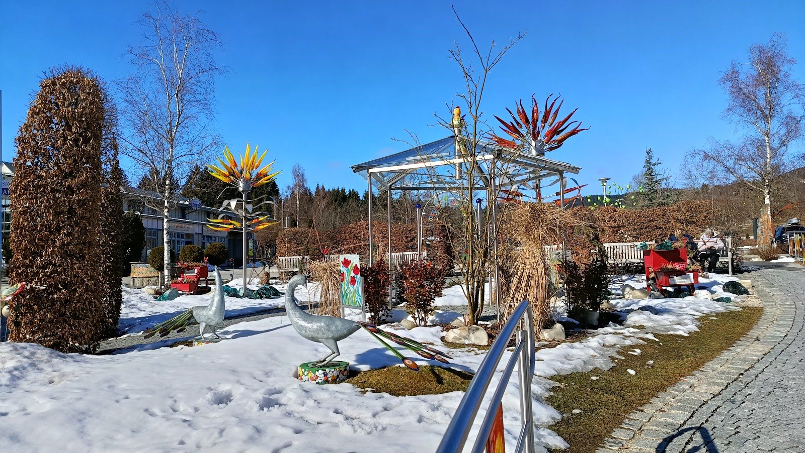 Bunte Glaskunst im verschneiten Außengelände von JOSKA