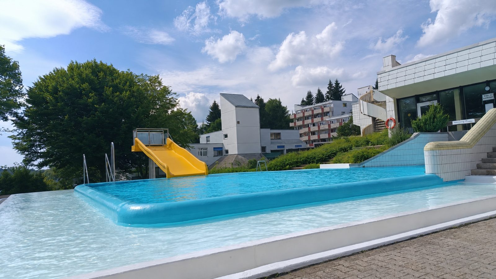 Außenpool mit Wasserrutsche im Sommer