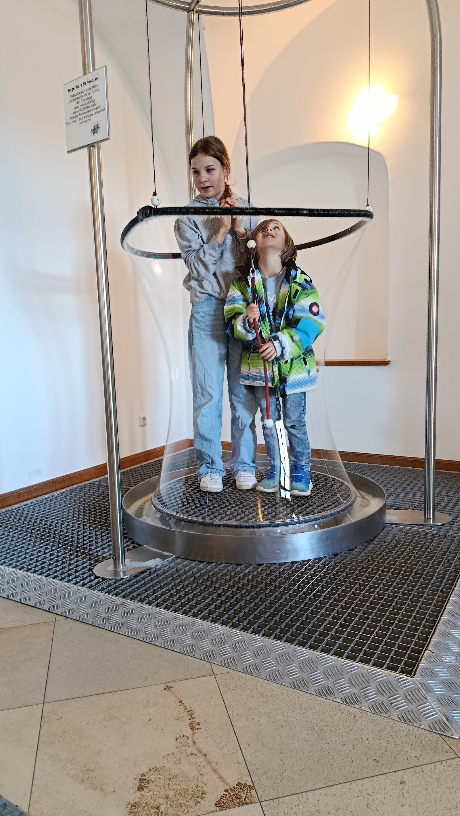 Kind steht beim Seifenblasenexperiment im Bayerwald Xperium in einer großen Seifenblase